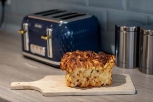 a piece of food on a cutting board next to a toaster at Murray's Neuk in Anstruther
