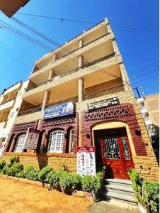 a red brick building with a red door at Kareem Hotel Luxor in Luxor