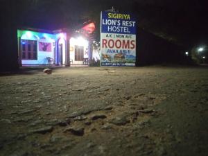 a sign in the middle of a street at night at Sigiriya Lions Rest Hostel in Sigiriya