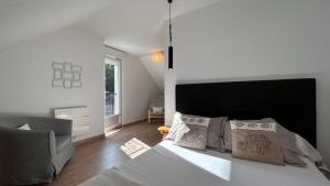 een slaapkamer met een groot wit bed en een bank bij Le Clos de l'Autel 