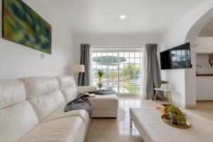 ein weißes Wohnzimmer mit einer weißen Couch in der Unterkunft MBird 19 Estoril Apartments in Estoril