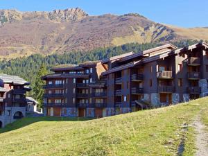 ein Gebäude auf einem Hügel mit Bergen im Hintergrund in der Unterkunft Studio cosy, animaux admis, parking disponible, Valmorel - FR-1-291-768 in Valmorel