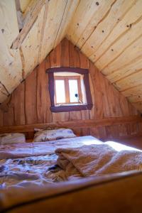 a bedroom in a log cabin with a window at Domek Baby Jagi Prawdziwy Survival 