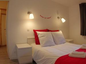 ein Schlafzimmer mit einem Bett mit roten und weißen Kissen in der Unterkunft Appartement cosy 3 pièces - 7 pers, skis aux pieds, 2 salles de bain, parking disponible - FR-1-291-747 in Valmorel