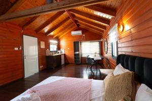 a bedroom with a bed in a wooden cabin at Pnina Yafa BaGalil Zimmer in Qiryat Shemona