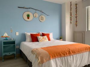 ein Schlafzimmer mit einem großen Bett und einer orangefarbenen Decke in der Unterkunft Suites con Vista en Floridablanca in Floridablanca
