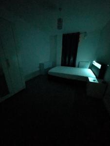 a bedroom with a bed in a dark room at Double room homestay in Reading