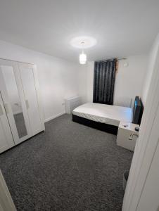 a small bedroom with a bed and a mirror at Double room homestay in Reading