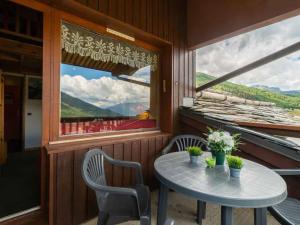 ein Tisch und Stühle in einem Zimmer mit Fenster in der Unterkunft Studio alpin mezzanine, 4 pers, animaux acceptés, parking en option - FR-1-291-1022 in Valmorel
