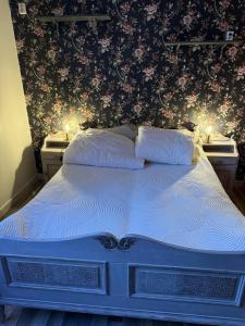 a bedroom with a bed with two night stands and flowers at Linsell in Sveg