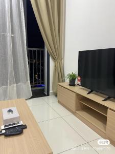 a living room with a television on a wooden entertainment center at Traders park Balakong 3 room Wi-Fi balcony unblock view in Cheras