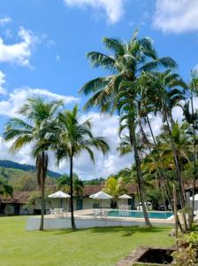 a resort with palm trees and a swimming pool at Hotel Fazenda Ponte Alta in Barra do Piraí