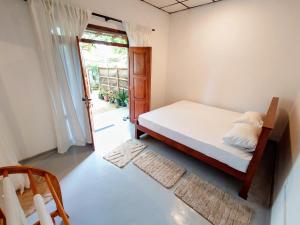 une chambre avec un lit et une porte donnant sur une cour dans l'établissement Eco Heaven House, à Ahangama 18 autres photos