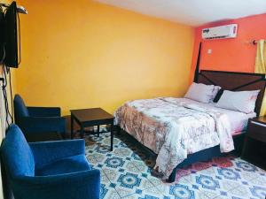 a bedroom with a bed and two chairs at Elevation Lodge Imatt in Freetown