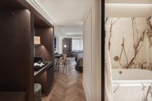 Habitación de hotel con bañera y dormitorio en MIM Andorra Member of Melia Collection, en Escaldes-Engordany