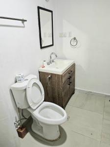 a bathroom with a toilet and a sink at Elevation Lodge Imatt in Freetown