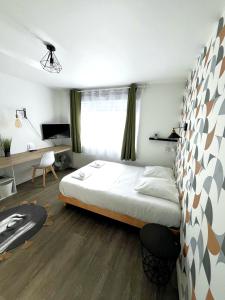 een slaapkamer met een bed en een bureau erin bij Les studios de l'Albatros in Saint-Nazaire