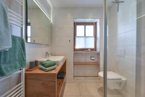 a bathroom with a sink and a toilet and a mirror at Schmölz Robert in Rieden am Forggensee +25 photos