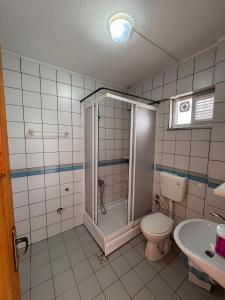 ein Badezimmer mit Dusche, Toilette und Waschbecken in der Unterkunft Orçın Apartments in Lapseki + 14 Fotos