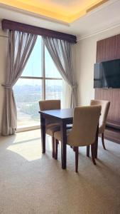 een eetkamer met een tafel en stoelen en een raam bij Dimond Vision Hotel in Jeddah