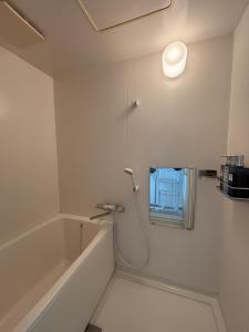 a bathroom with a bath tub and a shower at とまるん桜山 in Nagoya