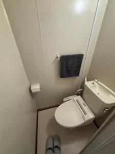 a bathroom with a toilet and a sink and a towel at とまるん桜山 in Nagoya