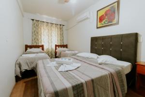 two beds in a room with two at Hotel Centro dos Canyons in Praia Grande