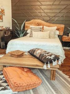 una cama con almohadas encima de un banco de madera en Secluded Treehouse Rental Ideal for Glamping in Alabama, en Brushy Pond