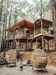 una casa en el bosque con dos sillas en Secluded Treehouse Rental Ideal for Glamping in Alabama, en Brushy Pond