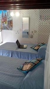 アルカスにあるLoft Centro Histórico Arucasのノートパソコン付きのベッド2台が備わる客室です。