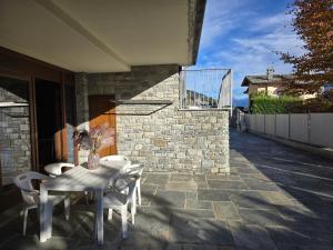 een tafel en stoelen op een patio met een balkon bij Appartamento con Biliardo Privato Patio e Parcheggio Aosta in Aosta +10 foto's