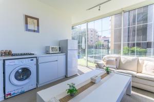 a living room with a washer and dryer at GlassHaus Rooftop 2-BR W Pool & Terrace in Ghazir in Admā