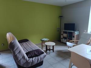 a living room with a couch and a tv at Appartement 2 à 4 personnes in Antraigues