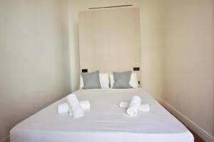 a white bed with two pillows on top of it at Global Adriano luxury 1 in Seville