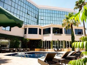 un hotel con piscina y tumbonas frente a un edificio en Amman West Luxury Hotel By Azar, en Amán