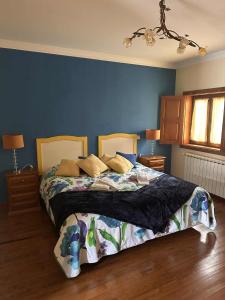 a bedroom with a bed with a blue wall at Solar de Rabal in Bragança