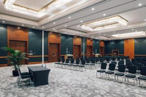 a conference room with rows of chairs and a stage at Pentahotel Leipzig in Leipzig +55 photos