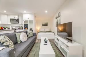 ein Wohnzimmer mit Sofa und ein Schlafzimmer in der Unterkunft 3 Mi to SoFi Stadium Cozy Studio with Patio! in Westmont