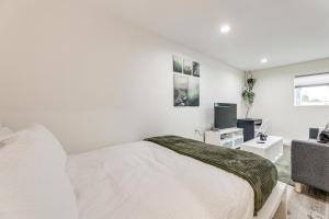 ein weißes Schlafzimmer mit einem Bett und einem Fernseher in der Unterkunft 3 Mi to SoFi Stadium Cozy Studio with Patio! in Westmont