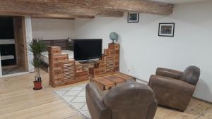 a living room with a couch and a television at La commanderie in Homps