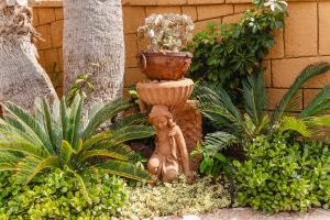 a statue of a woman in a garden with a planter at Europe Villa Cortes GL in Playa de las Americas