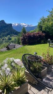 a metal bench sitting in a garden with plants at Le Lézard et la Grenouille BnB in Ovronnaz +34 photos
