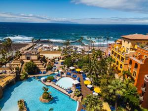 an aerial view of a resort with a swimming pool and the ocean at Europe Villa Cortes GL in Playa de las Americas +216 photos