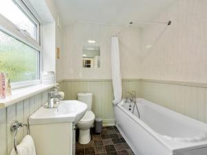 a bathroom with a sink and a tub and a toilet at 7 Guests - 6 Bedroom - Free Wi-Fi - NN15 in Burton Latimer