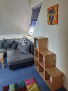 a living room with a couch and a book shelf at Ferienwohnung Ferienzimmer,nahe Rostock, Bentwisch Ot Albertsdorf bis 7 Personen in Bentwisch