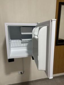 een lege koelkast met de deur open in een kamer bij Apartamento no Centro de Bandeirantes Ar, TV Smart, Ar Condicionado e Frigobar in Bandeirantes