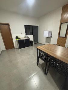 een lege kamer met een tafel en een keuken bij Apartamento no Centro de Bandeirantes Ar, TV Smart, Ar Condicionado e Frigobar in Bandeirantes +4 foto's