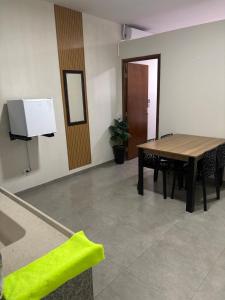 een eetkamer met een tafel en een televisie bij Apartamento no Centro de Bandeirantes Ar, TV Smart, Ar Condicionado e Frigobar in Bandeirantes