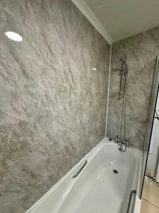 a bathroom with a white tub and a shower at Spacious apartment in Leigh woods in Bristol +8 photos