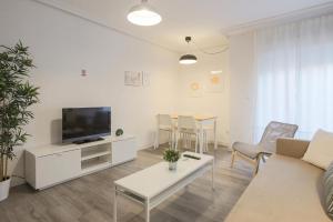 a living room with a couch and a tv at Lofty Justa in Seville